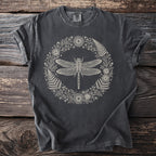 Dark grey t-shirt with line art of a dragonfly within a floral and fern wreath.