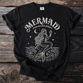 Black t-shirt with a white line drawing of a mermaid and the text "Mermaid, ocean sea siren folklore".