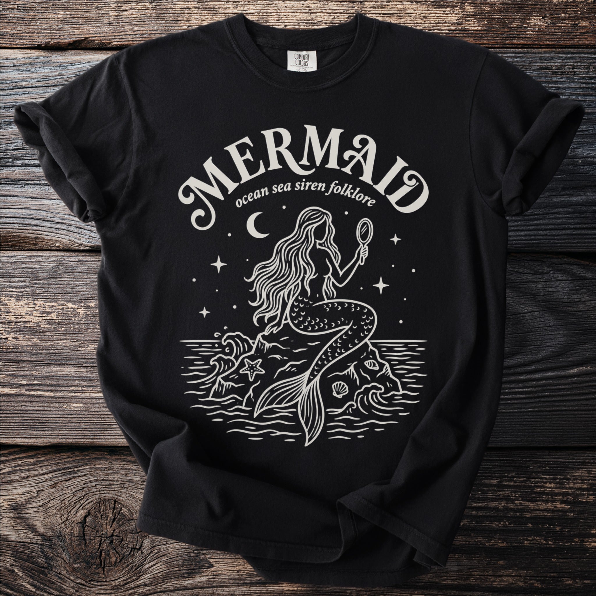 Black t-shirt with a white line drawing of a mermaid and the text "Mermaid, ocean sea siren folklore".