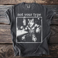 T-shirt with white text "not your type" over a drawing of a muscular werewolf sitting at a table with coffee.