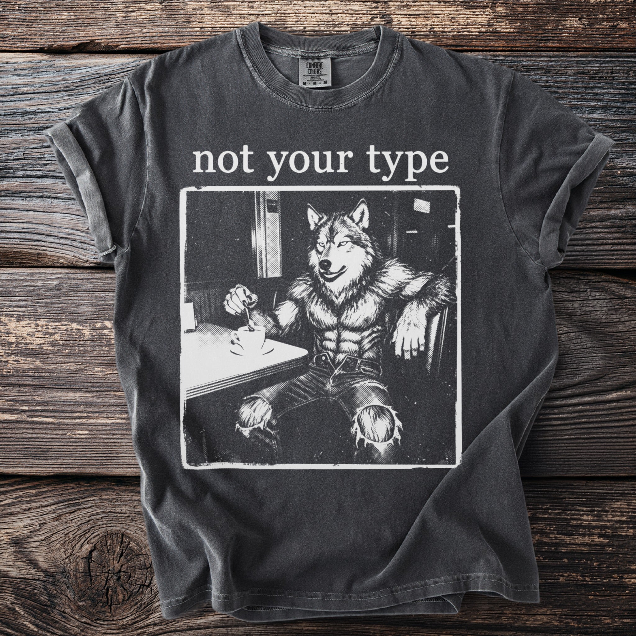 T-shirt with white text "not your type" over a drawing of a muscular werewolf sitting at a table with coffee.