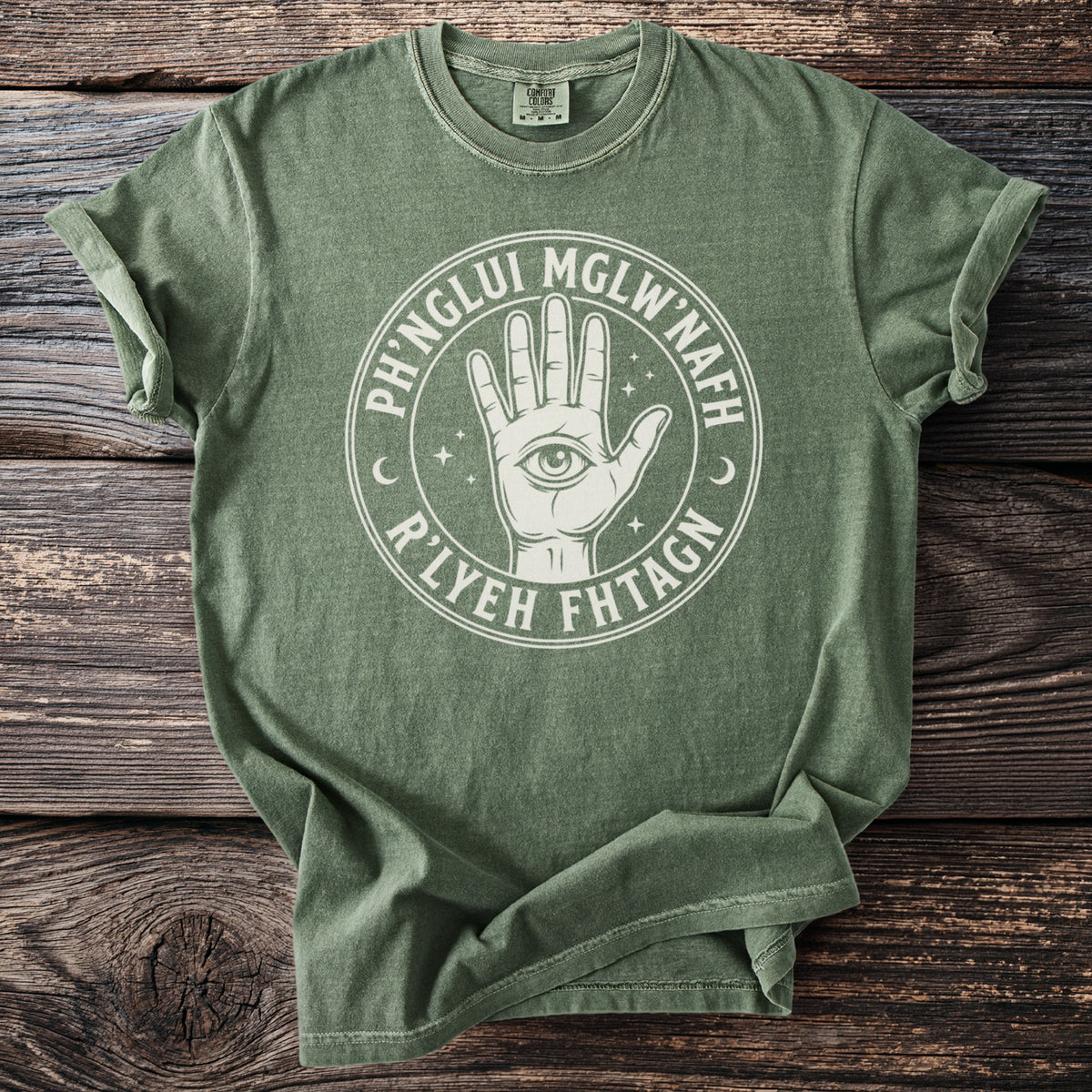 Green t-shirt with a white circular design of a hand with an eye and text.