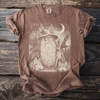 Brown t-shirt with a graphic of a wizard, wolves, eagles, and the moon.