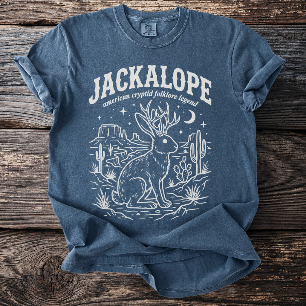 Blue t-shirt with white jackalope, desert, and text "Jackalope American cryptid folklore legend".