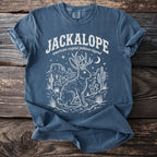 Blue t-shirt with white jackalope, desert, and text "Jackalope American cryptid folklore legend".