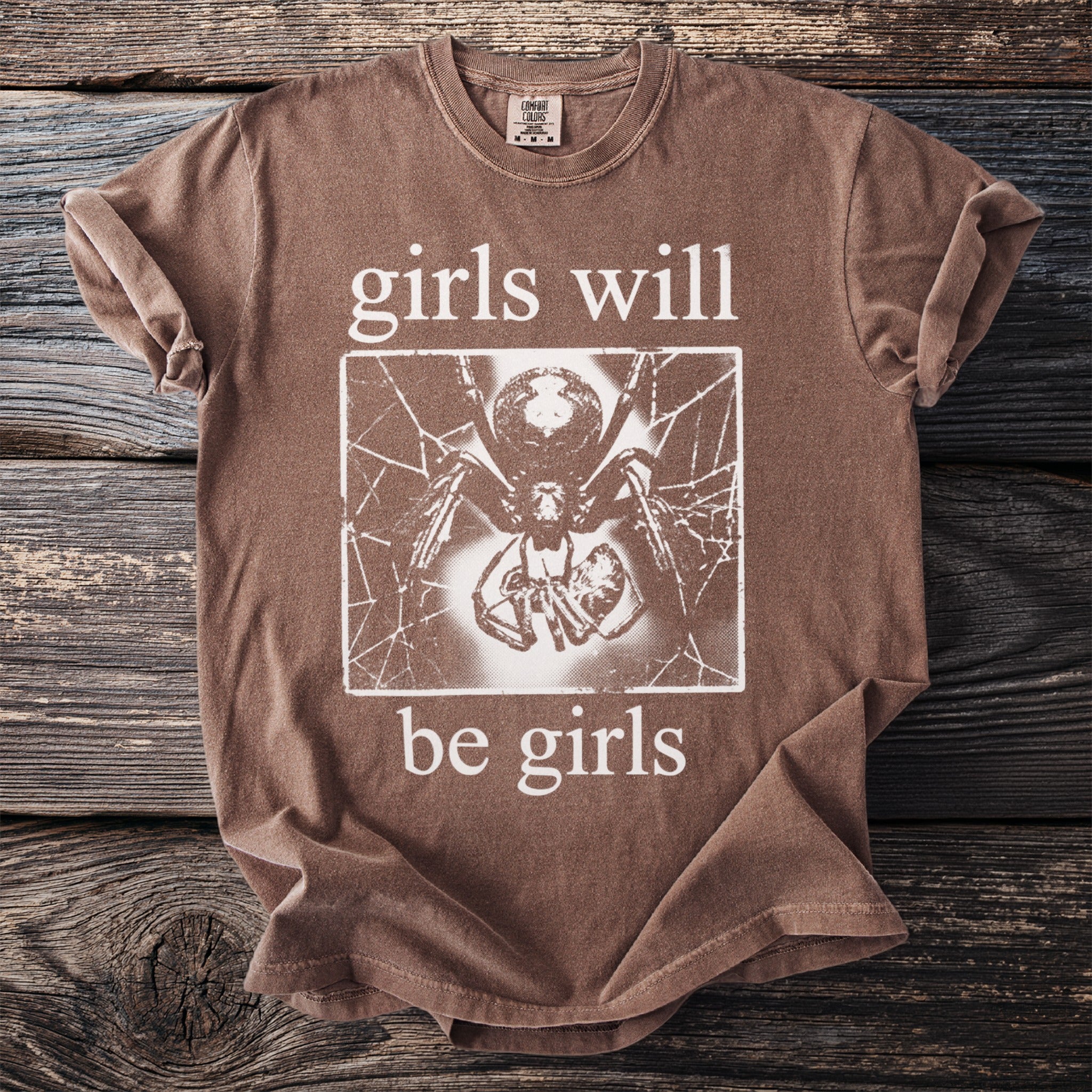 Brown t-shirt with "girls will be girls" text and spider graphic.