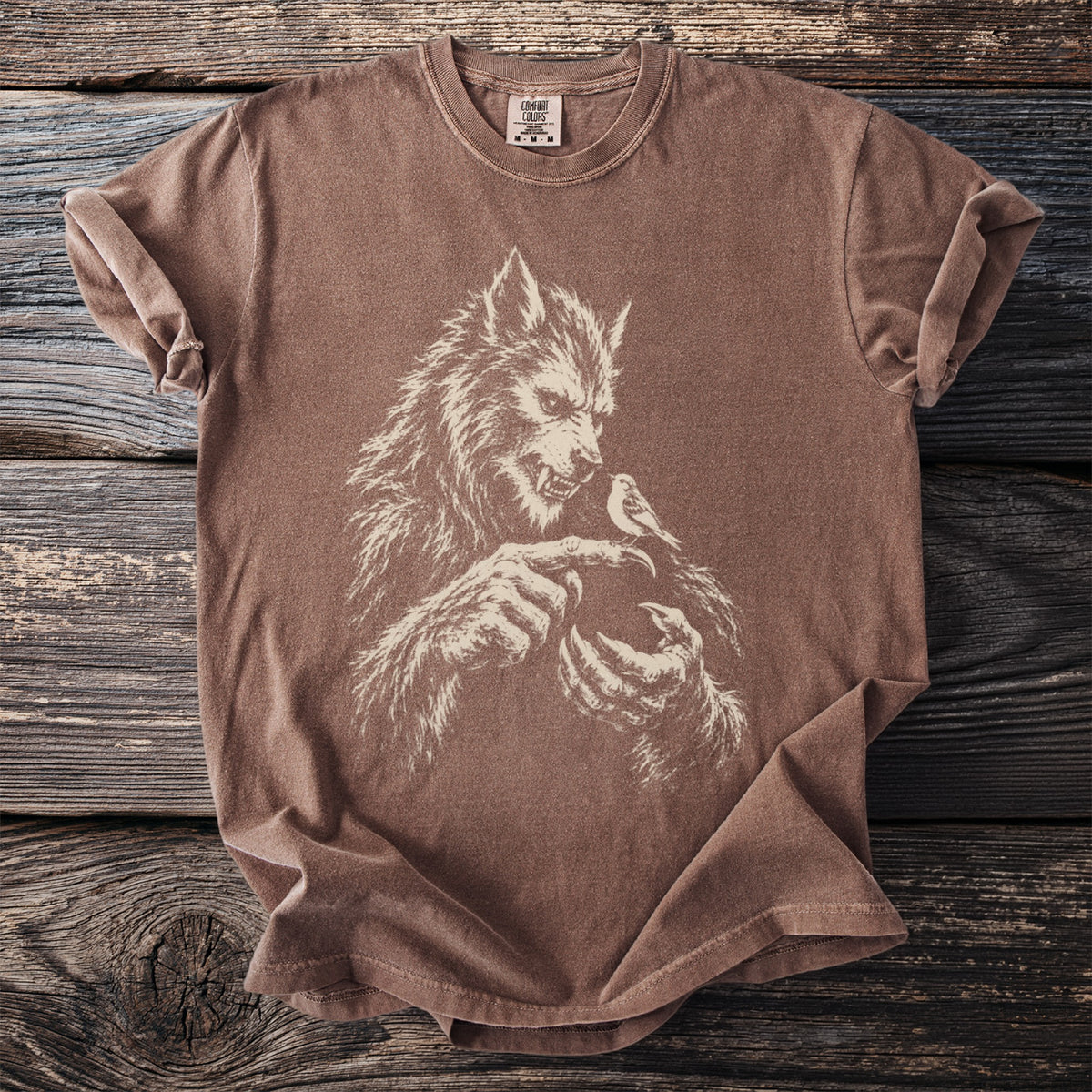 Brown t-shirt with white graphic of a werewolf and a bird.