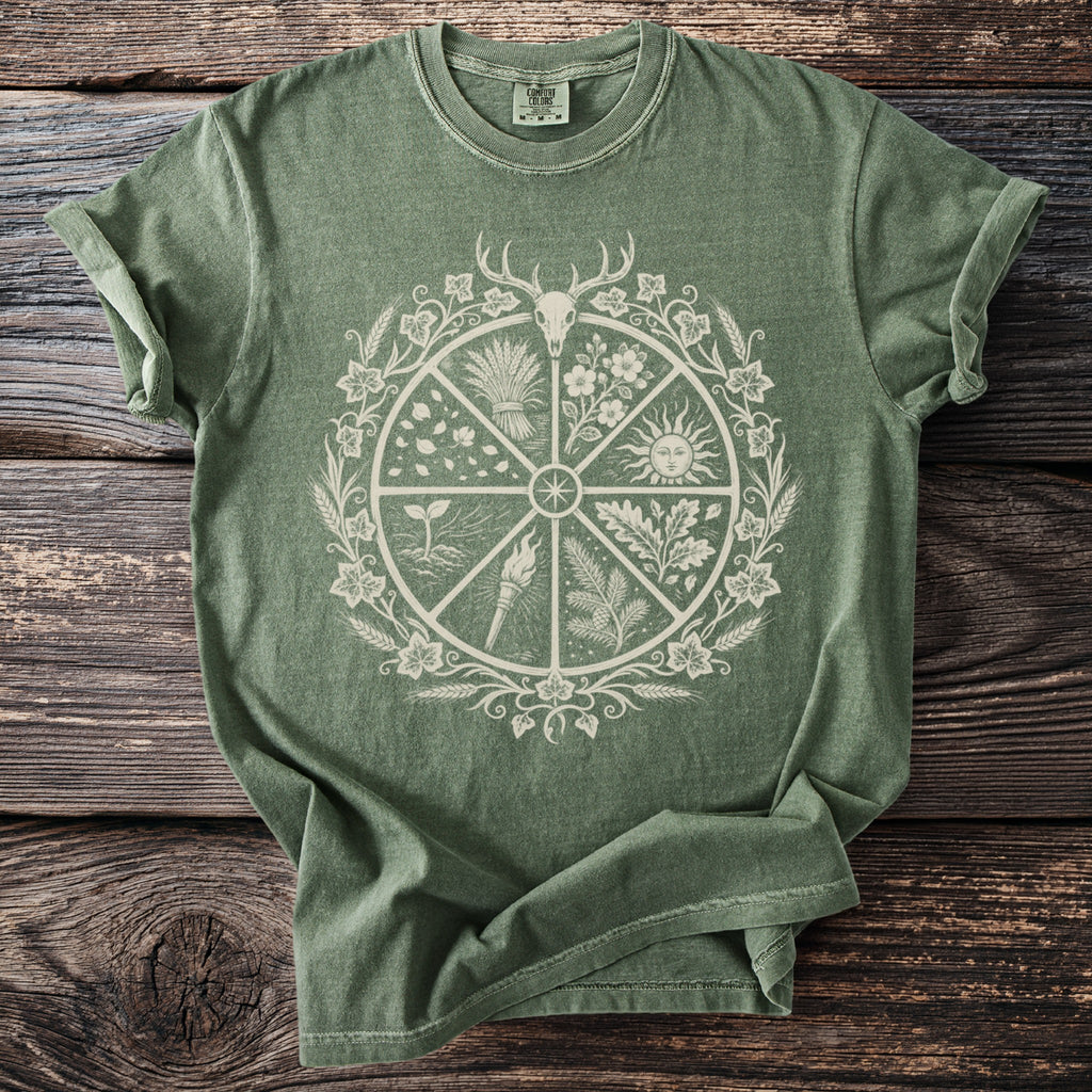 Green t-shirt with circular nature-themed graphic featuring a deer skull and sun.