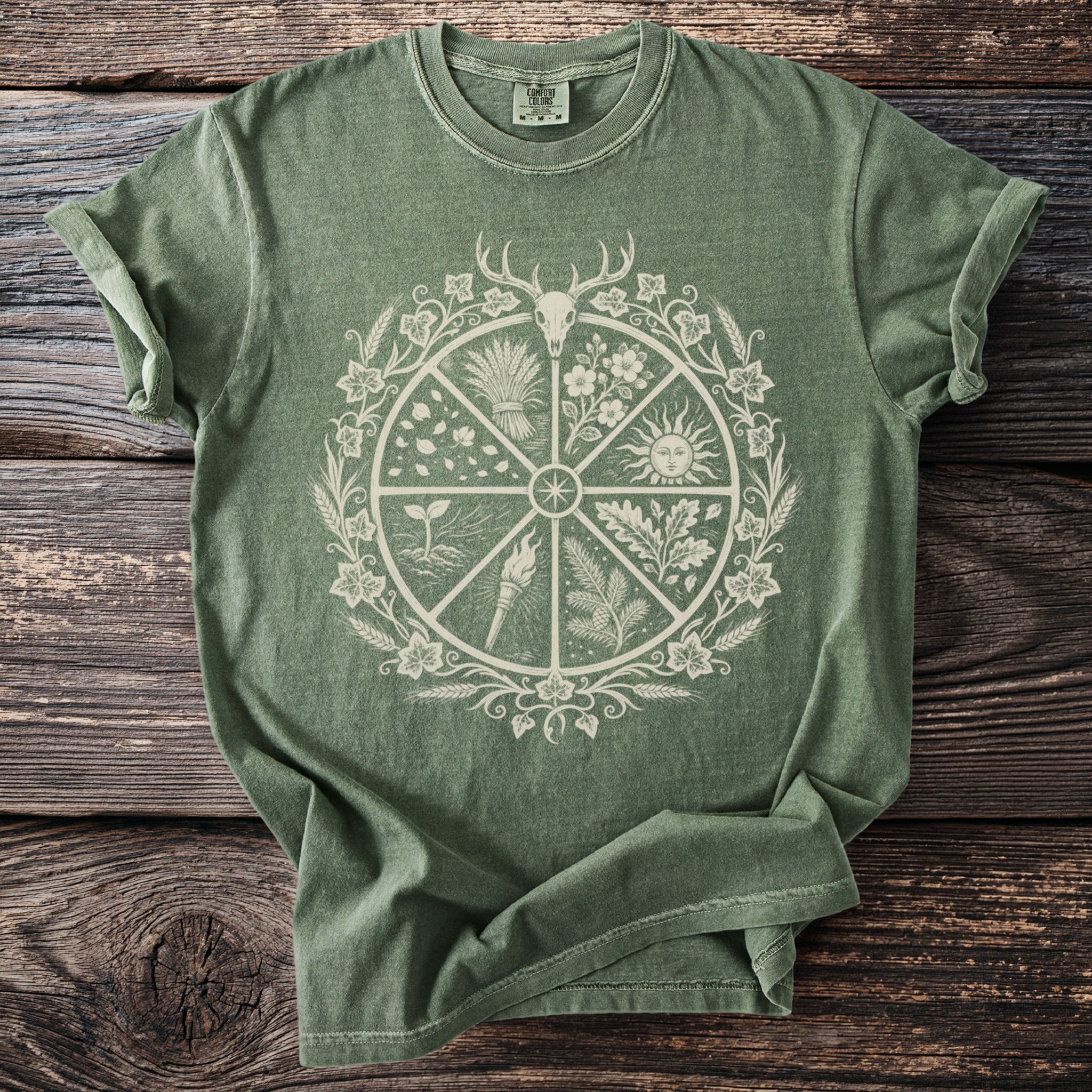 Green t-shirt with circular nature-themed graphic featuring a deer skull and sun.