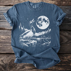 Two ducks in a white graphic on a blue t-shirt with a moonlit forest scene.