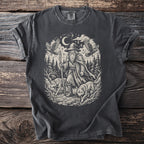 T-shirt graphic of a wizard with wolves and ravens in a forest under the moon.