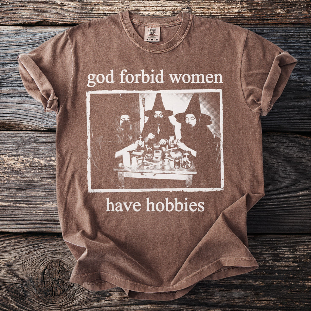 Brown t-shirt with "God forbid women have hobbies" and witch graphic.