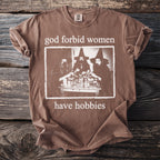 Brown t-shirt with "God forbid women have hobbies" and witch graphic.