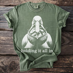 Green t-shirt with a pelican graphic holding many fish and text "holding it all in."