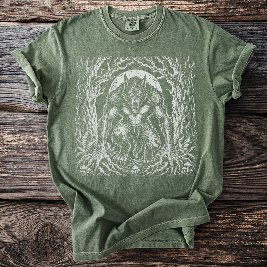 Green t-shirt with a white graphic of a werewolf in a forest under a full moon.