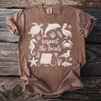 Brown t-shirt with white "respect the locals" text and various marine life graphics.