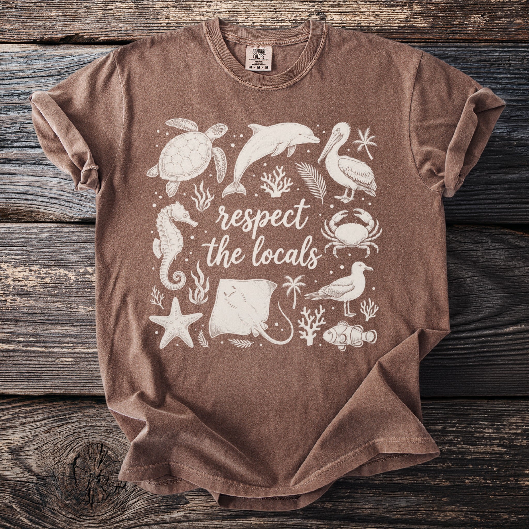 Brown t-shirt with white "respect the locals" text and various marine life graphics.