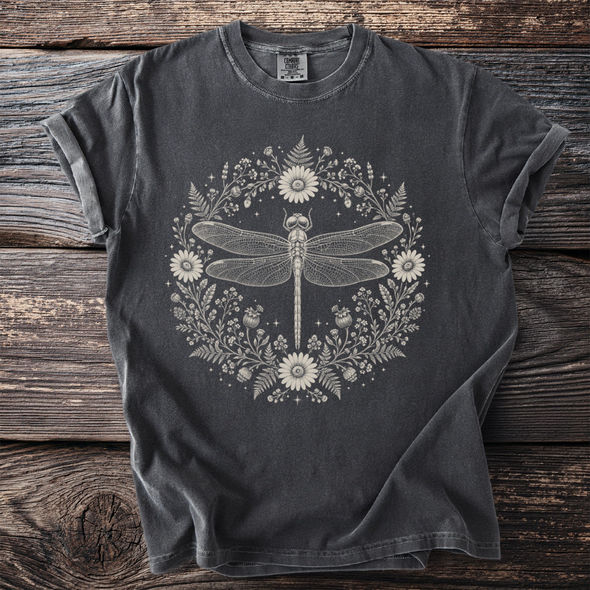 Grey t-shirt with a circular design of a dragonfly surrounded by flowers and ferns.
