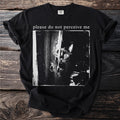 Black t-shirt with a dark image of a cat peeking from behind a textured surface and "please do not perceive me" text.