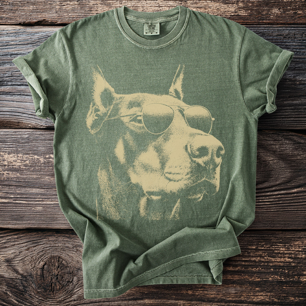 Green t-shirt with a vintage-style Doberman Pinscher wearing sunglasses graphic.
