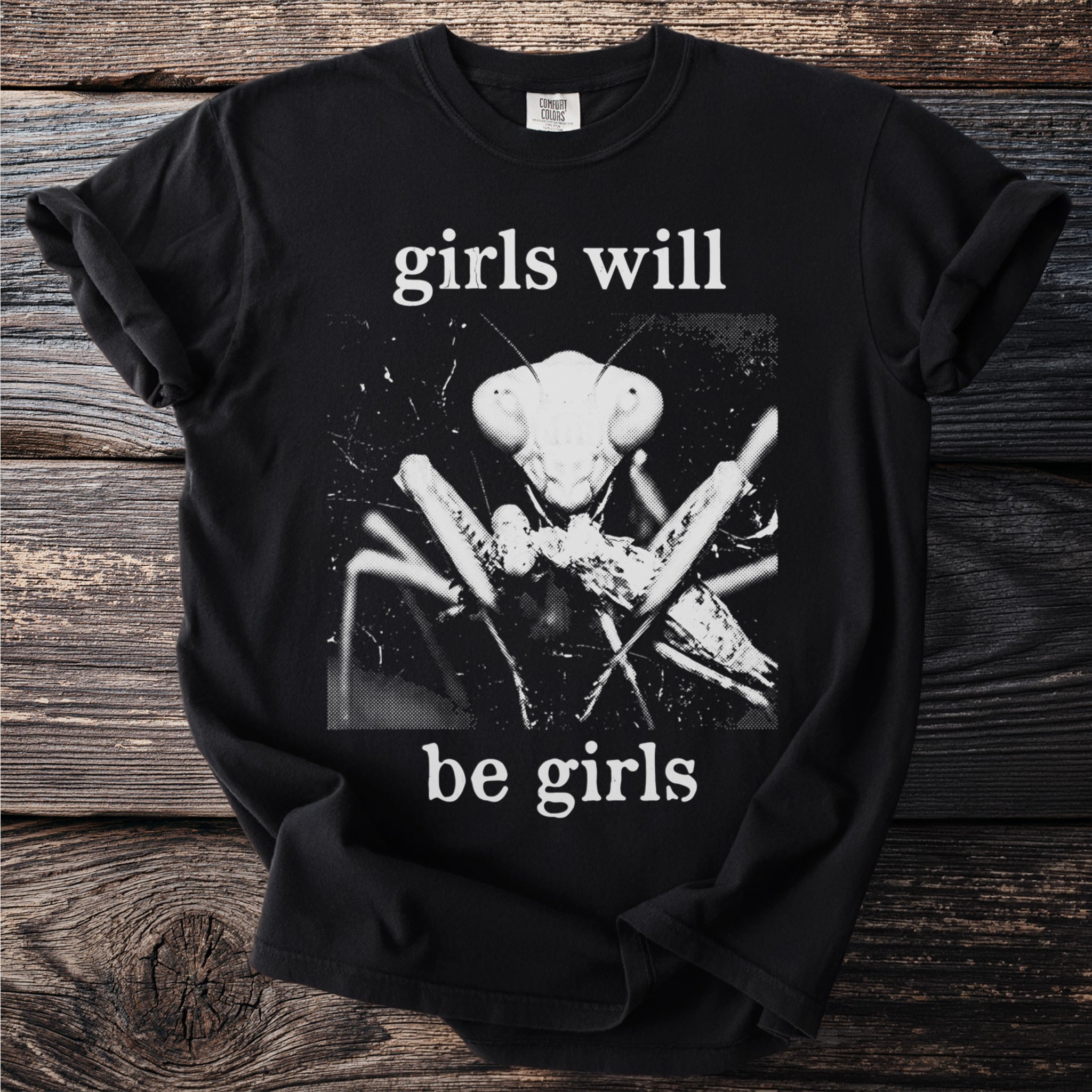 Black t-shirt with "girls will be girls" and a praying mantis graphic.
