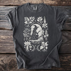 Charcoal t-shirt with a white linework design of a witch and mystical plants.