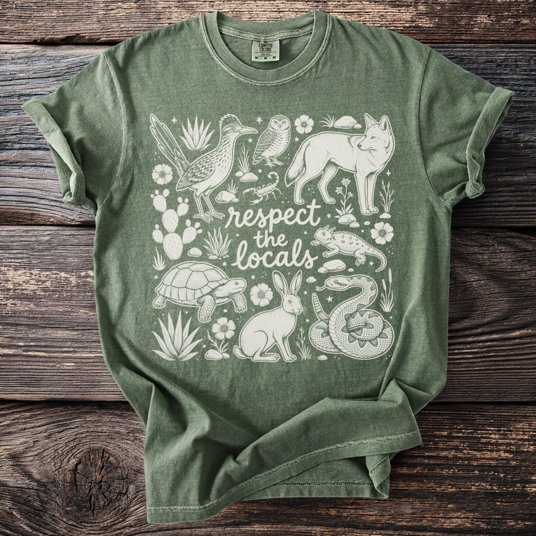 Green t-shirt with white desert animals and plants, and "respect the locals" text.