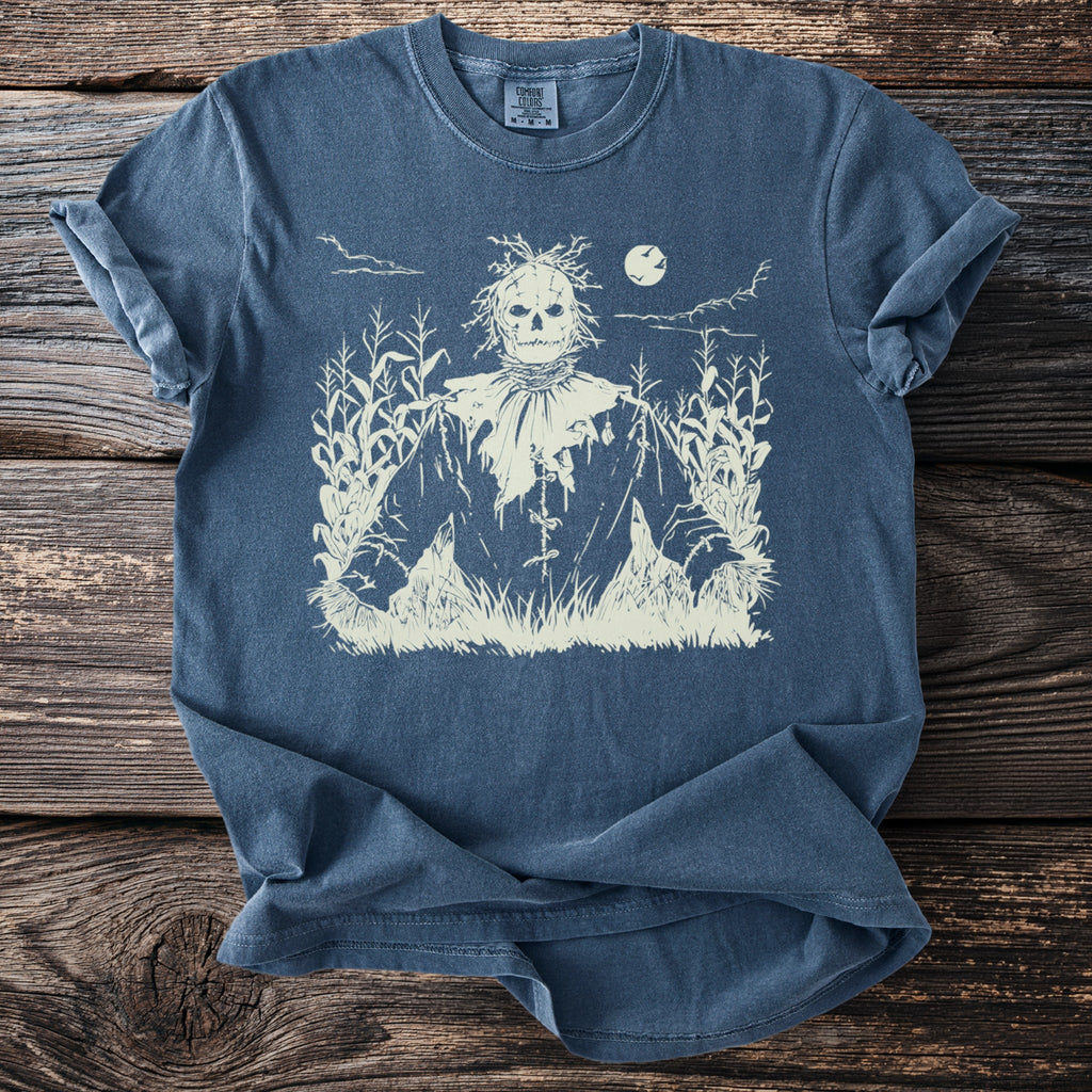 T-shirt with a cream-colored scarecrow design in a cornfield at night.