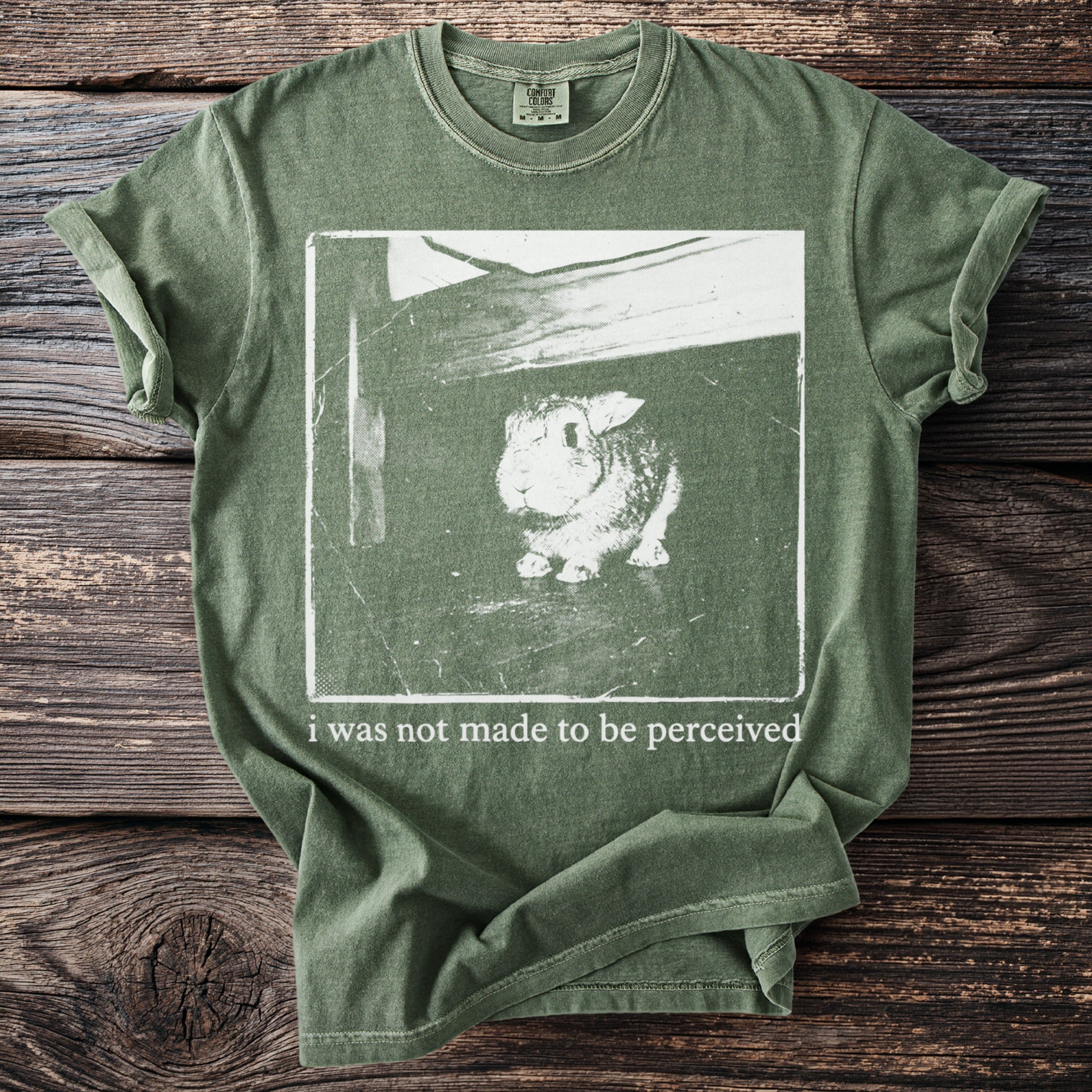 Green t-shirt with rabbit graphic and text "i was not made to be perceived".