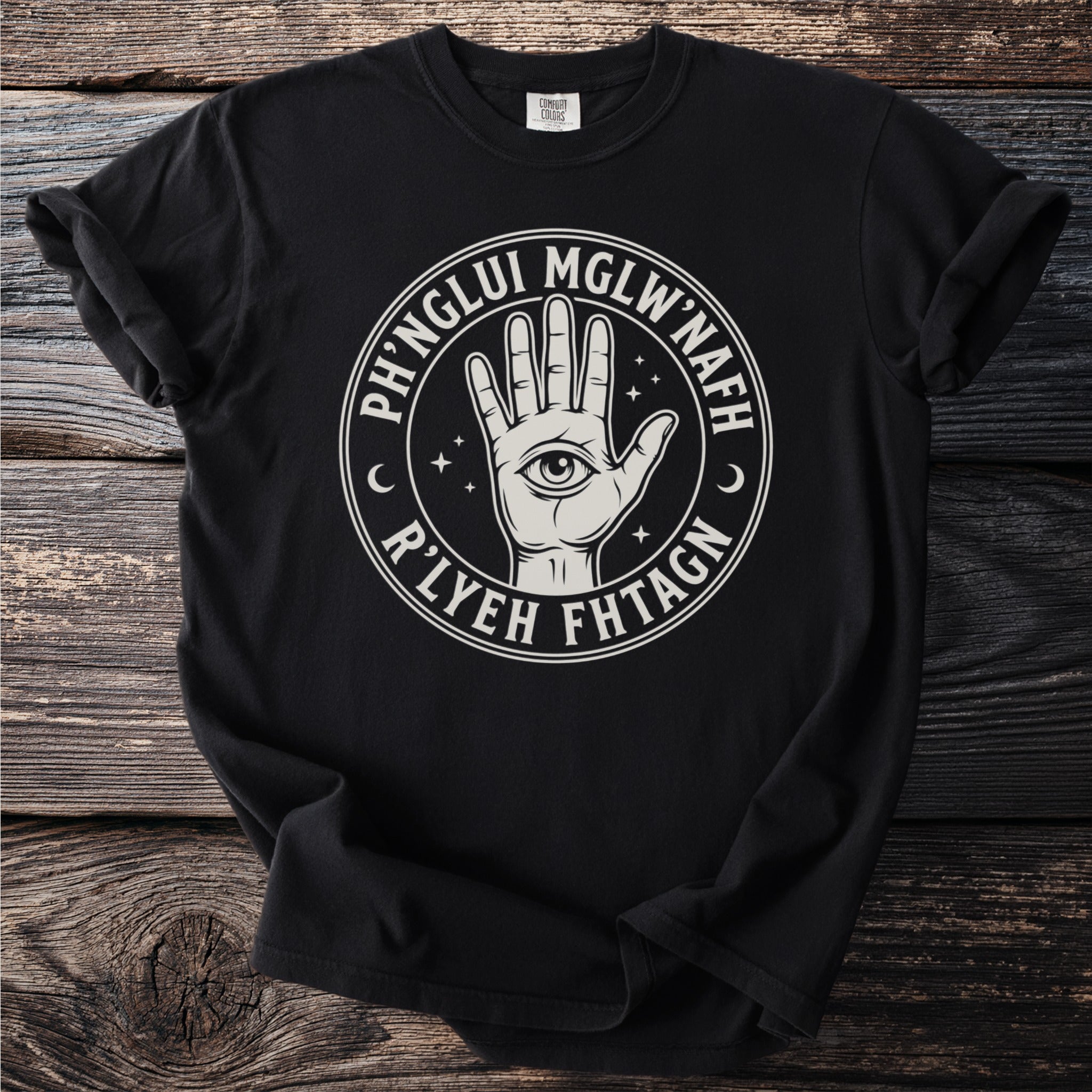 Black t-shirt with a circular emblem featuring a hand with an eye, stars, and text.