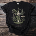Black t-shirt with botanical illustration of poison garden plants titled The Hedgewitch's Herbarium.