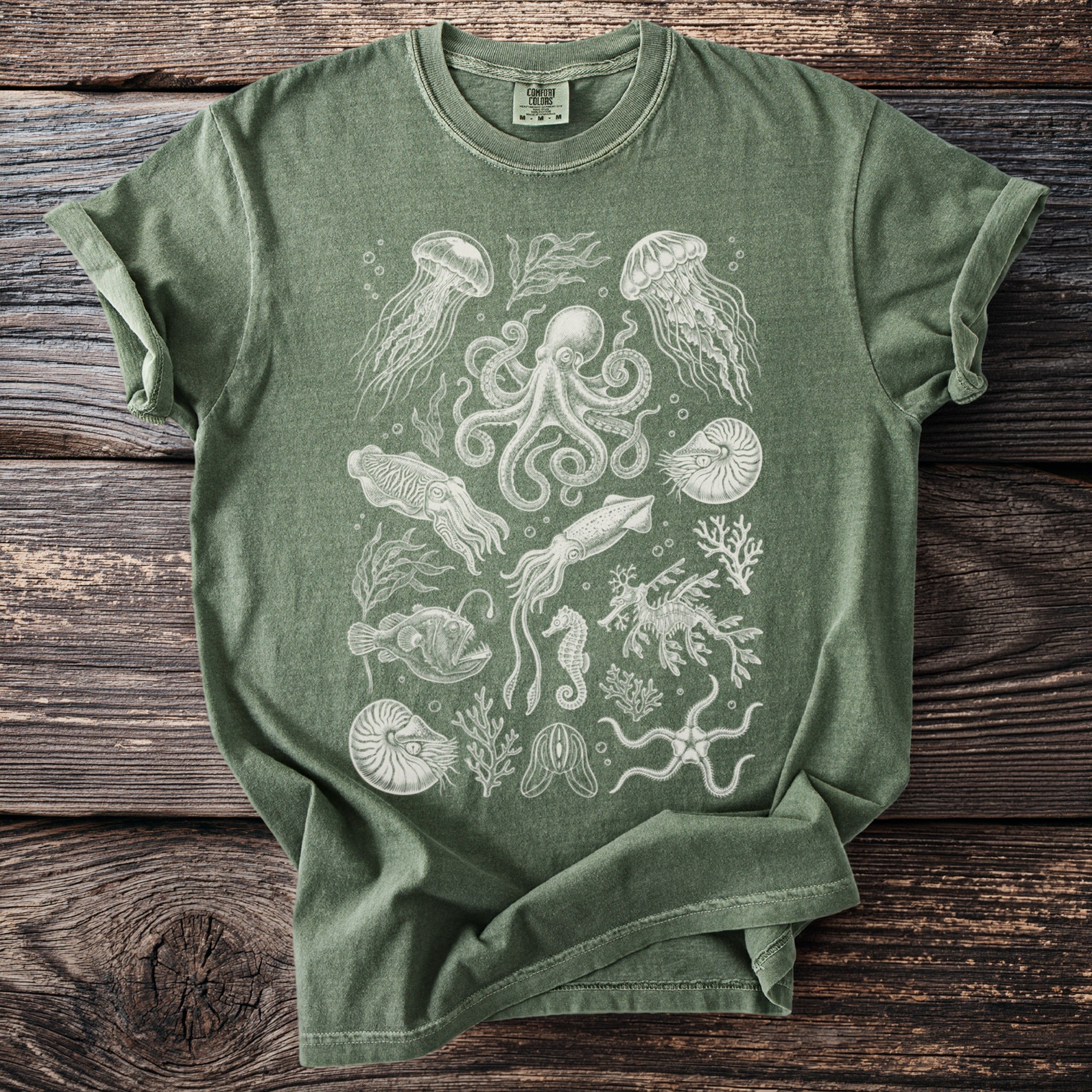 Green t-shirt with printed white line art of marine life including octopus, jellyfish, and seahorse.