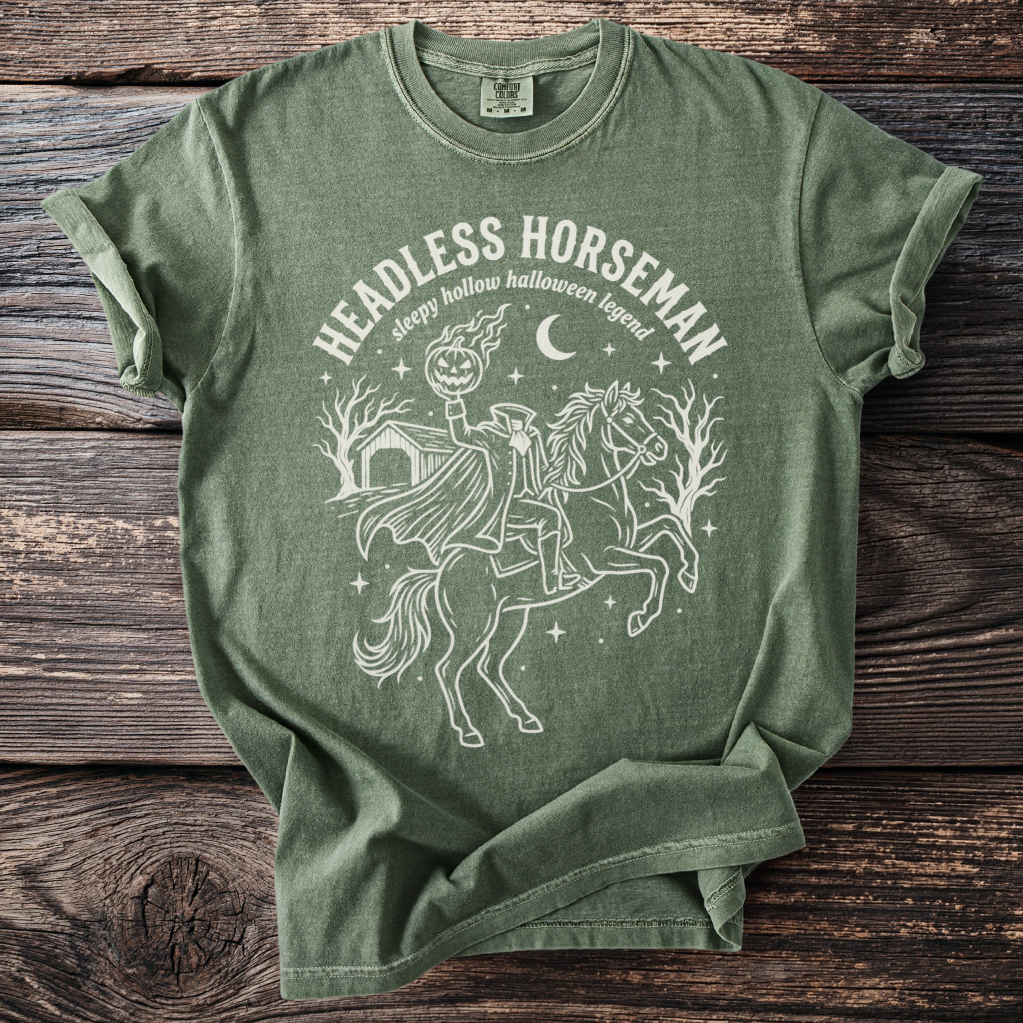 Green t-shirt with Headless Horseman and pumpkin graphic and text.