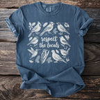 Blue t-shirt with white line art illustration of various birds and text "respect the locals".