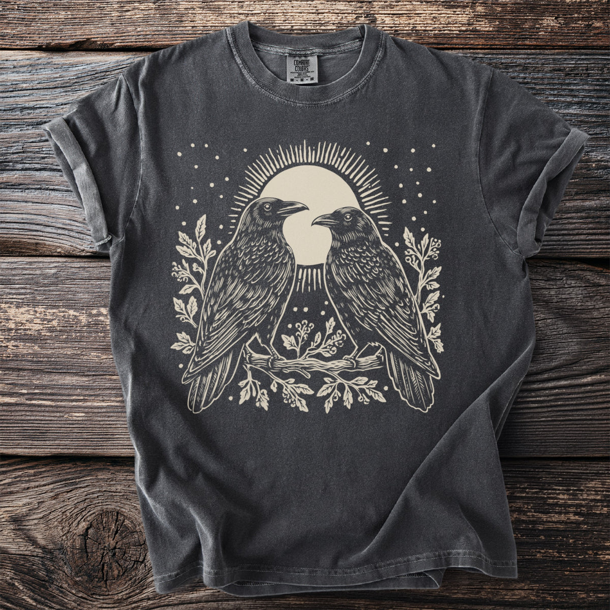 Dark gray t-shirt with a light-colored graphic of two ravens on a branch with a moon behind them.