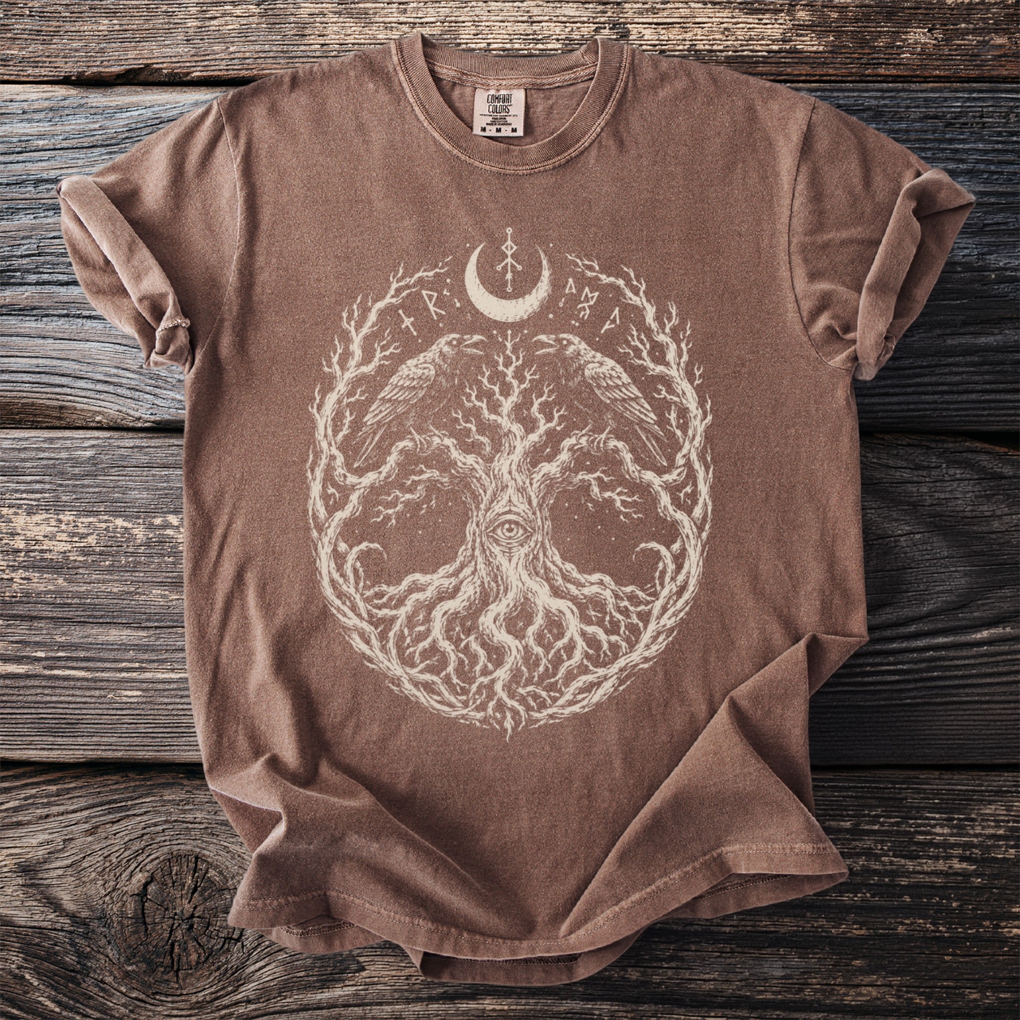 Brown t-shirt with a white tree of life design featuring ravens and an eye.