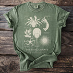 Green t-shirt with vintage illustrations of marine life and "The Tidal Cabinet" title.