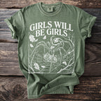 Green t-shirt with white graphic of spider, web, moths, and text "GIRLS WILL BE GIRLS".