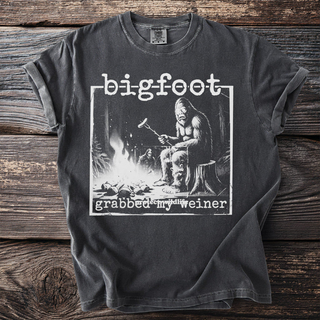 Bigfoot t-shirt graphic with text "bigfoot grabbed my weiner" and Bigfoot cooking by a fire.