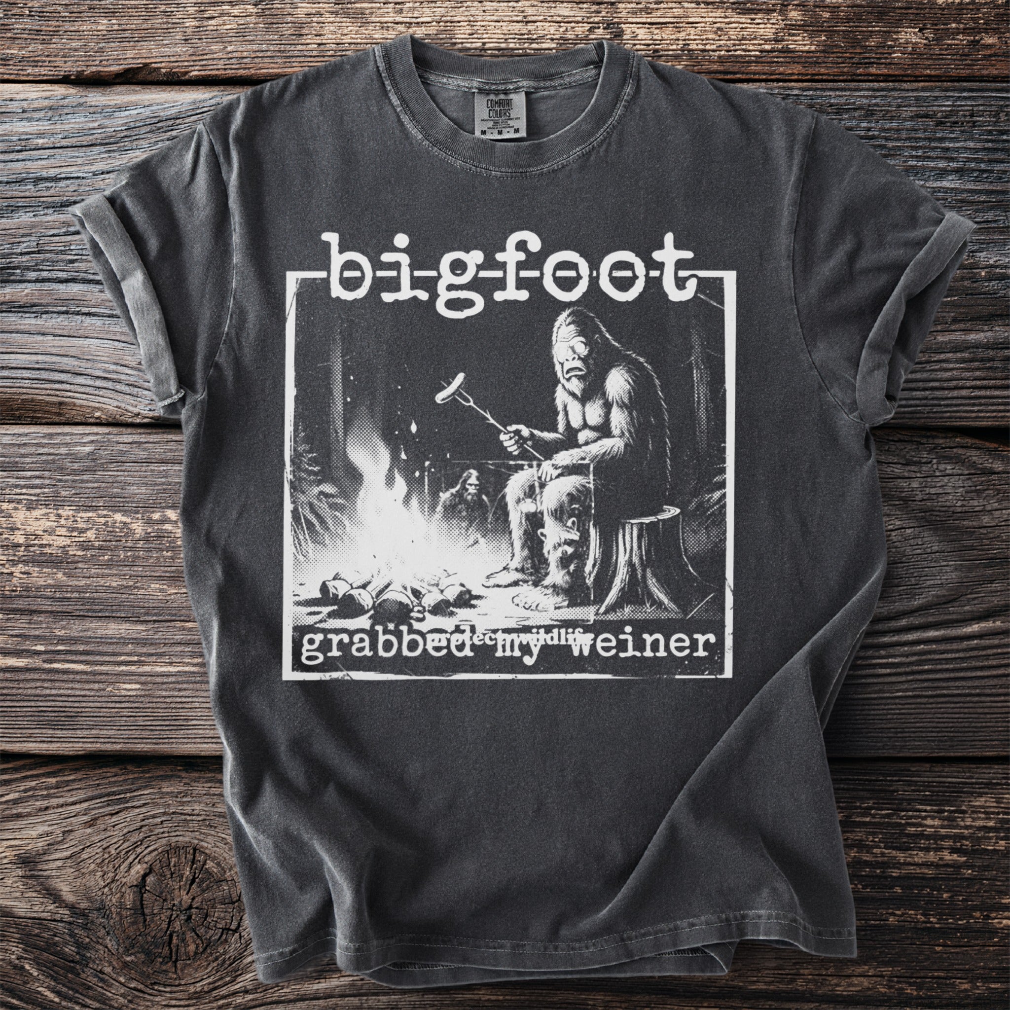 Bigfoot t-shirt graphic with text "bigfoot grabbed my weiner" and Bigfoot cooking by a fire.