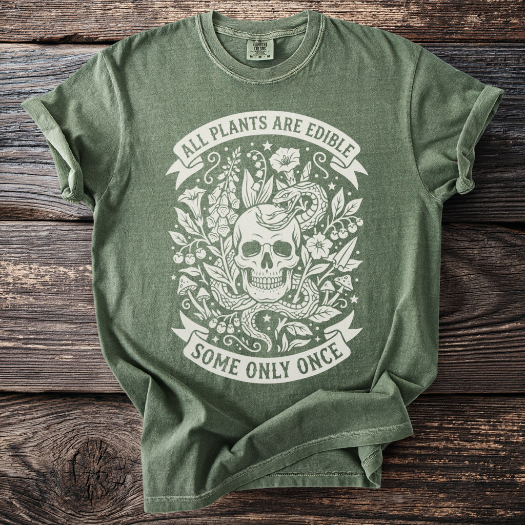 Green t-shirt with white graphic of skull, snake, plants, and text.