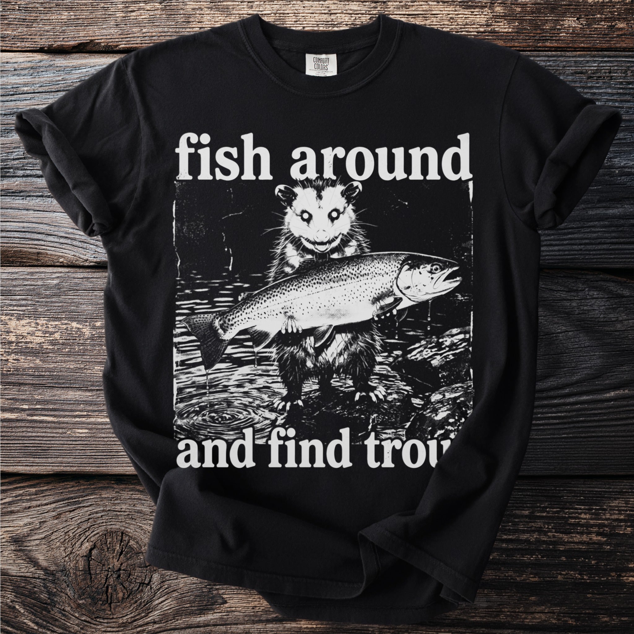 Black t-shirt with opossum holding a trout and text "fish around and find trout".