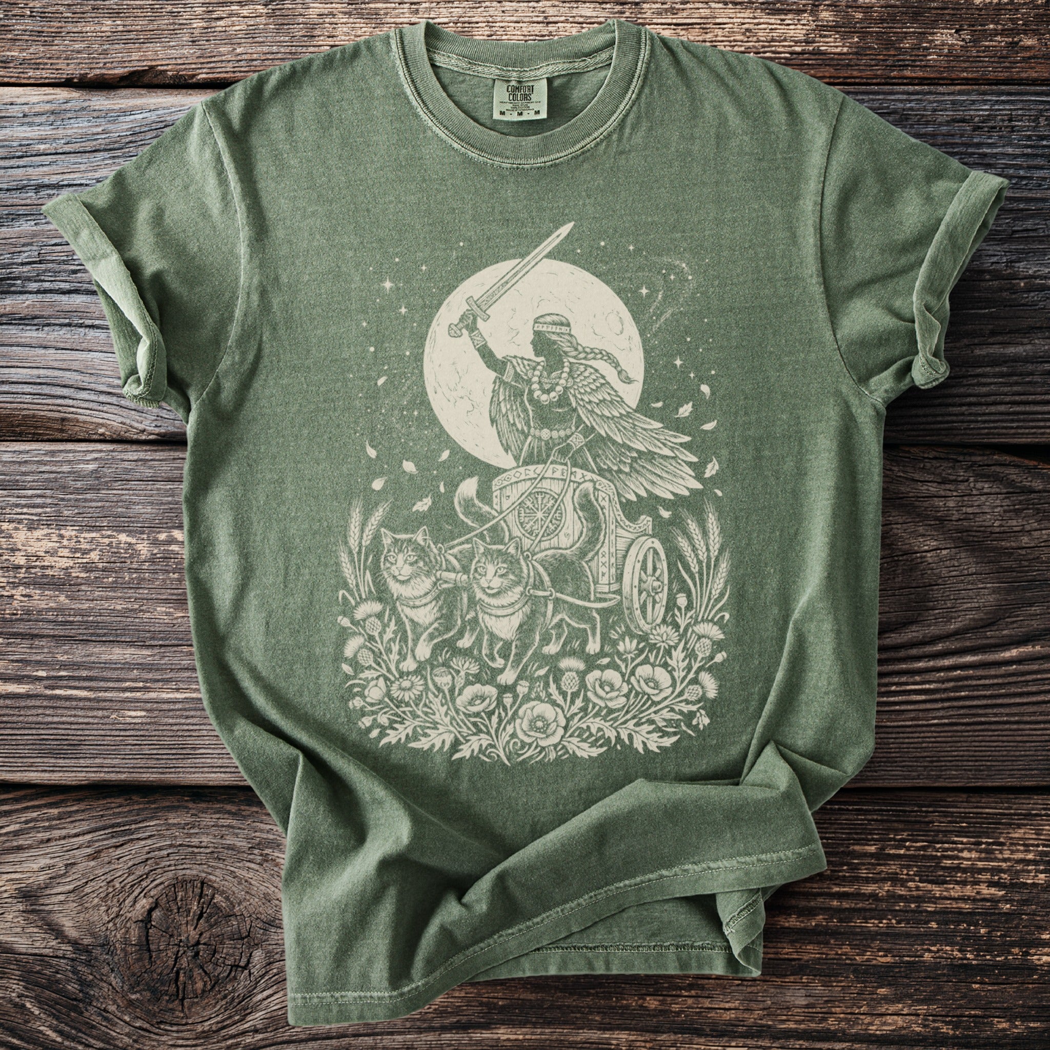 Green t-shirt with a cream print of a winged figure in a chariot pulled by cats.