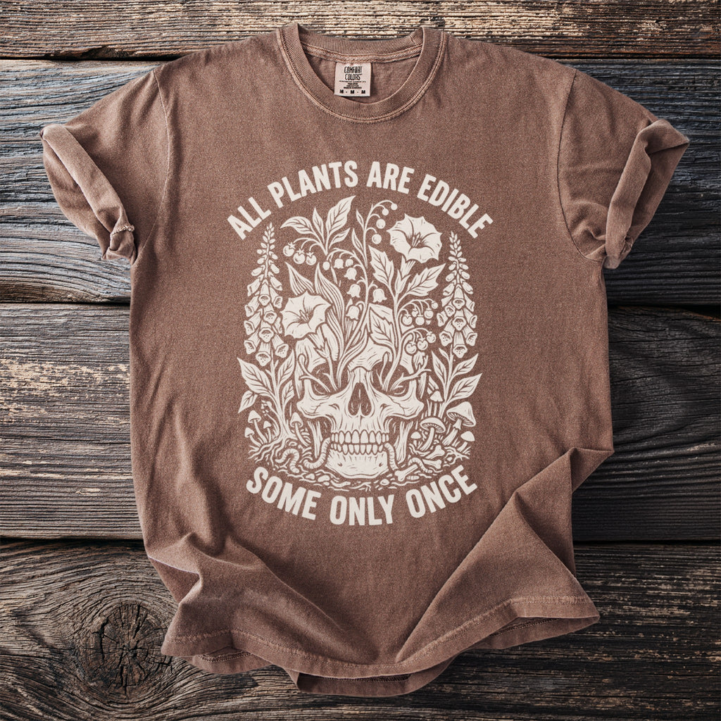 Brown t-shirt with white text and illustration of skull surrounded by plants.