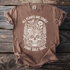 Brown t-shirt with white text and illustration of skull surrounded by plants.