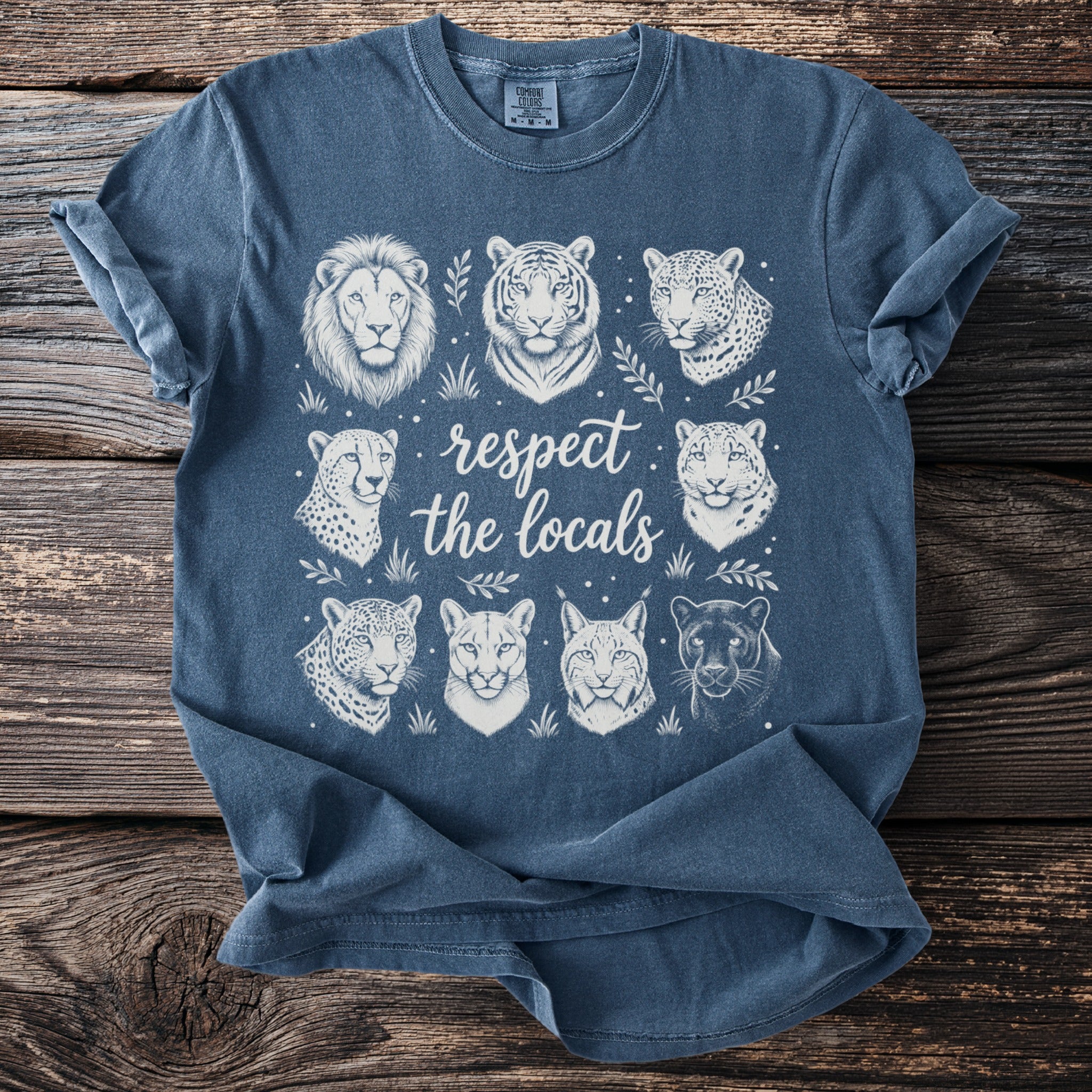 Blue t-shirt with white line art of feline faces and text "respect the locals"