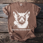 Brown t-shirt with a front graphic of a bat face and text "tiny body enormous dread".
