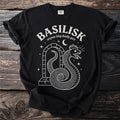 Black t-shirt with white "BASILISK serpent king deadly gaze" text and snake illustration.