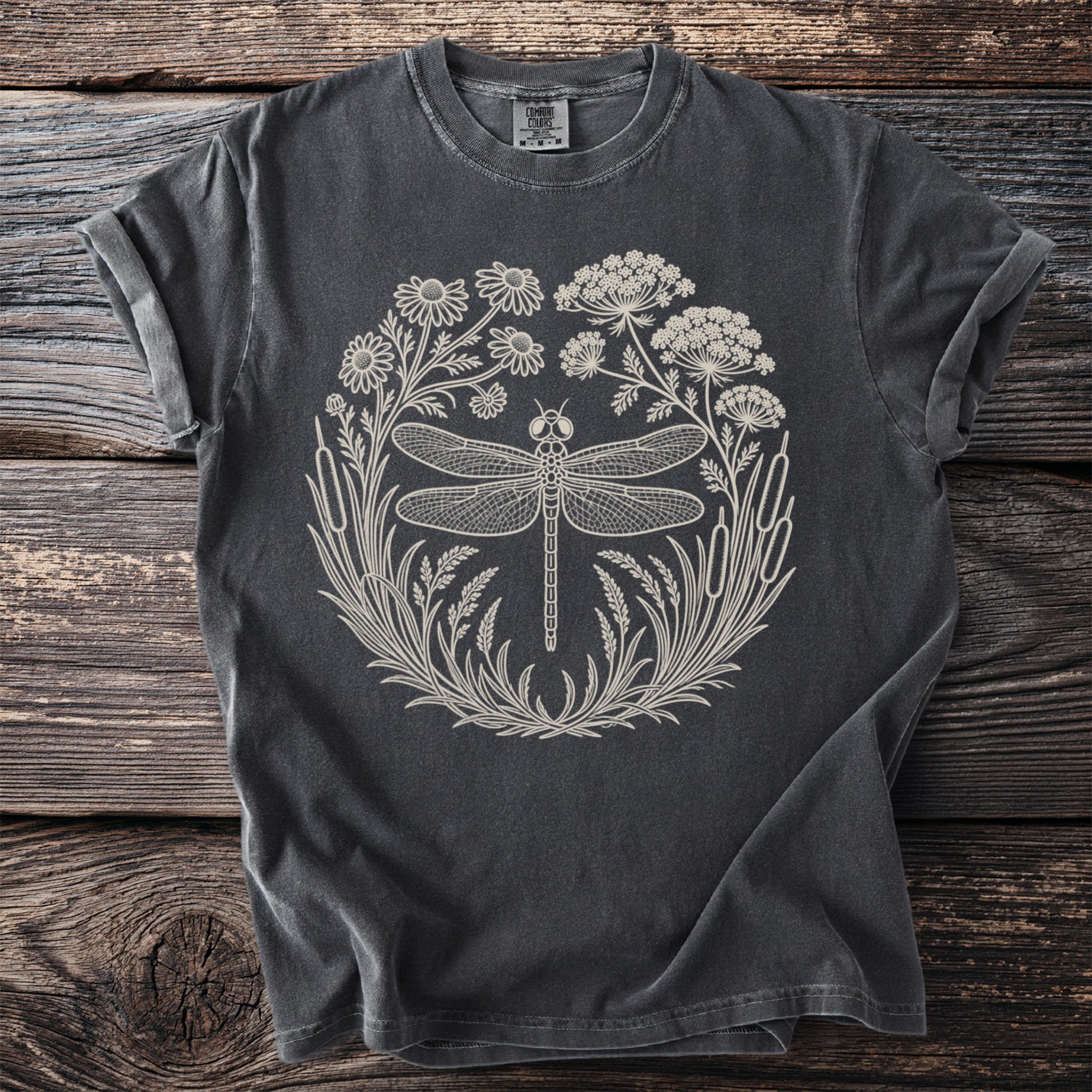 Dark grey t-shirt with a cream outlined dragonfly and floral wreath design.