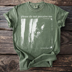 Green t-shirt with a black cat peeking from behind a vertical line and text "please do not perceive me".